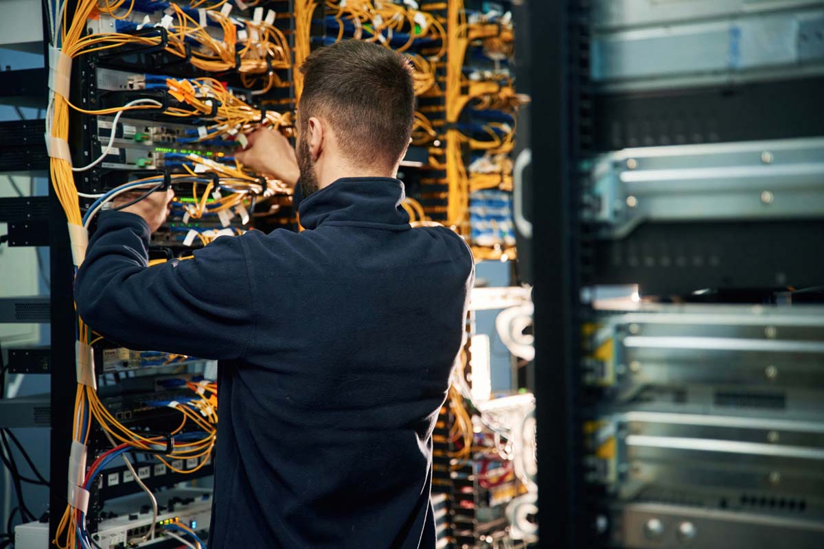 Young man is working with internet equipment and wires in server room Euroinformatica Srl Euroinformatica Srl gestione rete aziendale