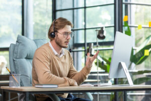 An angry young businessman in a headset sitting at a computer and talking on a video call in the office with clients team partners Unsatisfied with work burning deadlines firing from a job Euroinformatica Srl Euroinformatica Srl Euroinformatica Srl Euroinformatica Srl